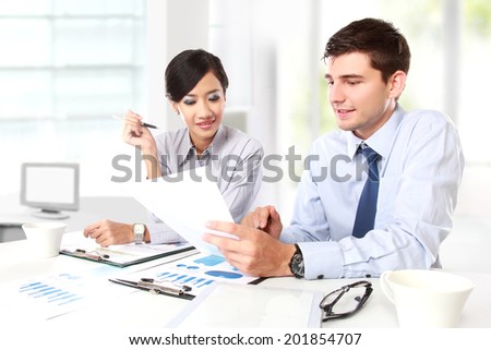 Image of two young business people at the meeting in the office