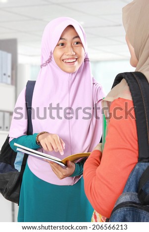 Two Muslim girl student study together discussing something in classroom