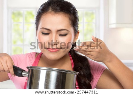 young woman Chef hold a pan for cooking and smell of cooking