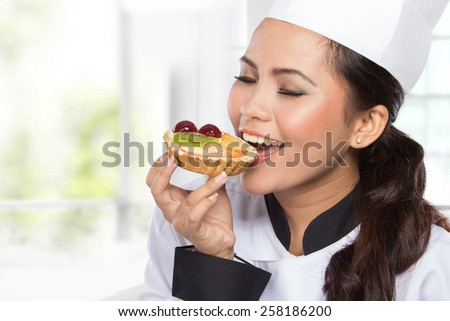 portrait of young female chef eat cake