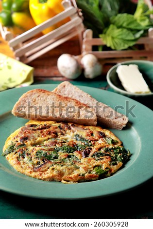 portrait of healthy breakfast spinach mushroom omelette served with toast and butter
