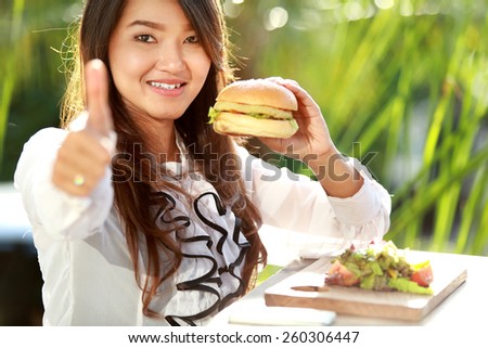 portrait of young woman having lunch and give thumbs up for delicious food