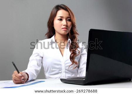 Portrait of business woman working with laptop on the table from side angle