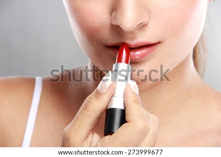 close up portrait of beautiful caucasian model applying lipstick