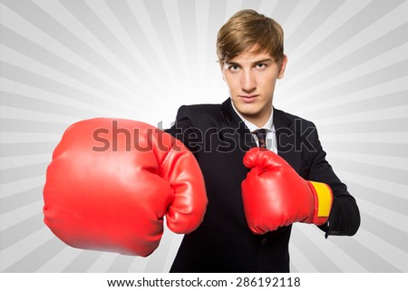 A portrait of a young businessman with a boxing gloves concept, isolated