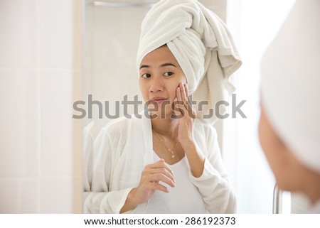A portrait of an asian woman taking care her face