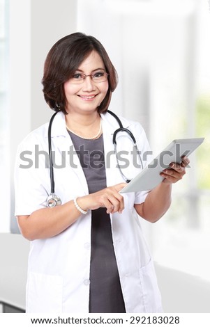 middle aged woman doctor using tablet computer isolated over white background