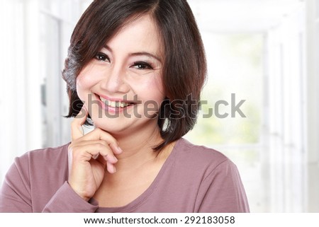 portrait of happy casual middle aged woman with arm crossed