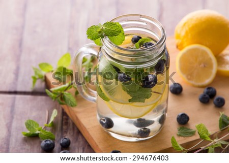 portrait of Summer fresh fruit drink. fruit Flavored water mix with lemon, blueberry and mint leaves