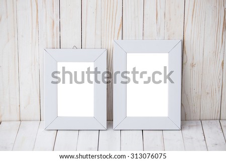 A portrait of two kind sizes of white frame on wooden background