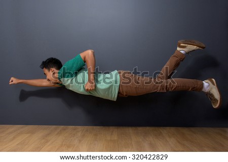 portrait of young man posing flying like superman. ready for your design