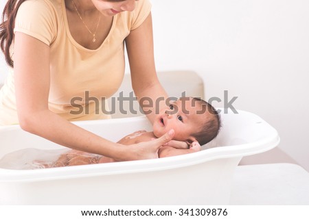 Similar – Image, Stock Photo Lovely baby infant being kissed by mom and dad at home.