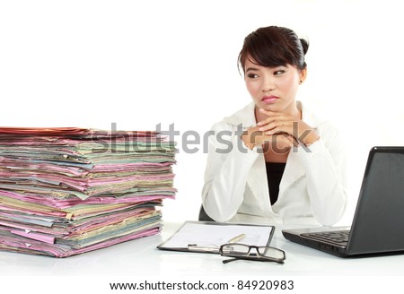 young business woman with laptop and many paper stressed at work