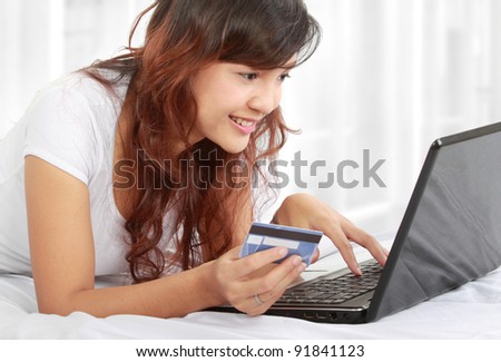 Cute online shopping woman lying on the bed