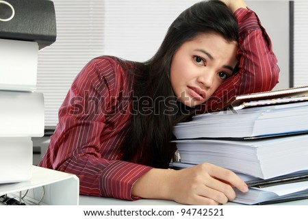 young business woman with many paperwork stressed in the office