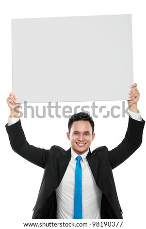 Portrait of a smiling young business man holding a blank billboard on top of his head