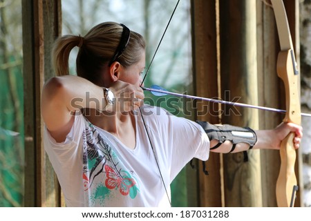 woman shooting with a bow and arrows