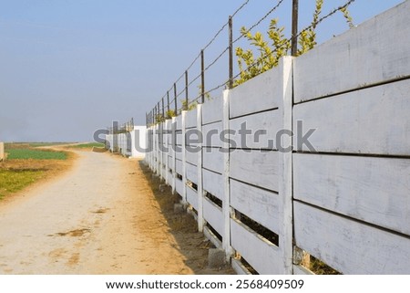 Foto Bild Reihen von Stacheldraht im Hintergrund ein verlassenes Wohngebäude mit zerbrochenen Fenstern. Konzept von Geisterstadt, Isolation und Sicherheit. Gefängnis, Flüchtling, Einsamkeit