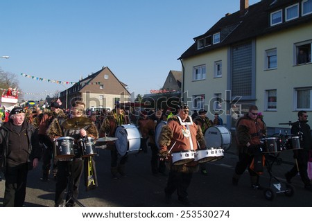 DUISBURG, GERMANY - 15.02.2015 An unidentified woman and man in the annual carnival costumes & masks are on the road.  They give sweets to children and adults, play a musical instrument, having fun.