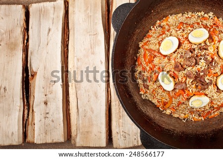 traditional central asia pilaf in kazan on logs