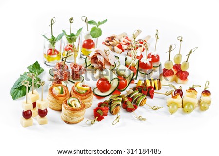 great attractive set of canapes with vegetables, cheese, fruits, berries, salami, seafood, meat and decoration on white background studio isolated