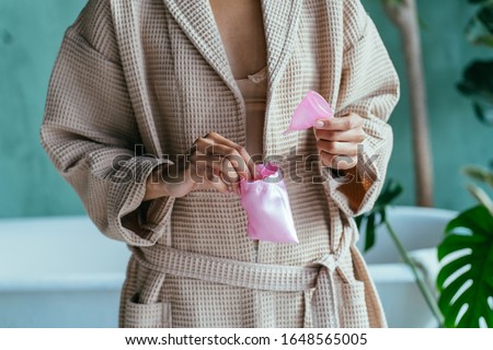 Foto Bild Silikon-Menstruationstasse mit Tampons.weibliches intimes alternatives gynäkologisches Hygiene-Konzept