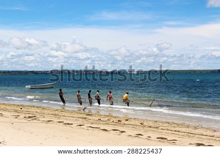 ANTSIRANANA, MADAGASCAR - Feb 26: fishermen are drawing fishing net out of  Emerald Sea of Antsiranana (Diego Suarez), north of Madagascar, on February 26, 2015