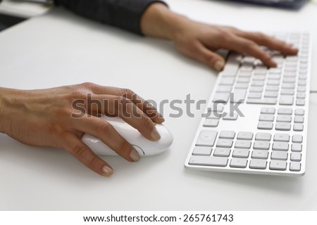 Italy, female hands on a computer mouse and keyboard