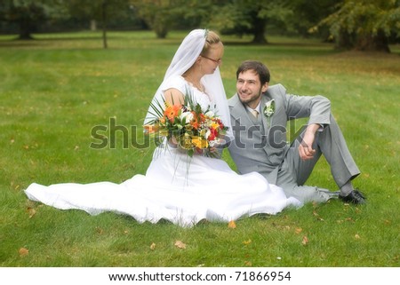 Wedding pair sitting on the lawn