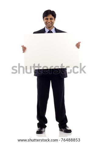 Full length of a happy young Indian businessman holding blank sign- copyspace isolated over white background