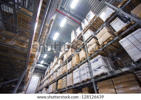 Rows of shelves with cardboard boxes on modern warehouse in store