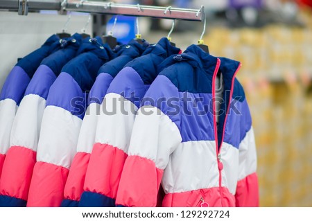 Stripes color winter jackets on stand in sport store