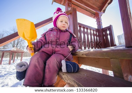 Adorable girl sit on stairs on wooden slide for kids on playground