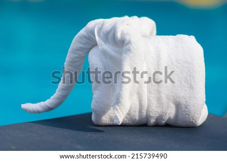Towels in form of elephants on sunbed at luxury swimming pool