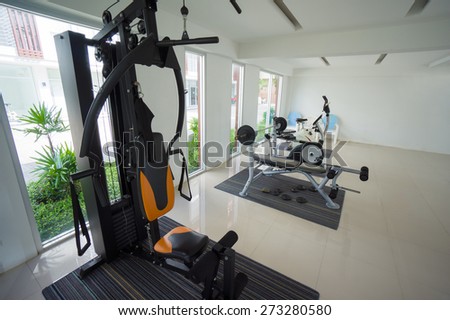Gym with power dumbell lifting and stationary bicycle standing equipment