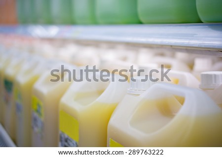Rows of large juice bottles in fridge in supermarket