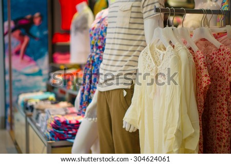 Light blouse and man and woman mannequins in dress and t-shirt in cloth store