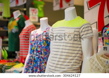 Man and woman mannequins in dress and t-shirt in cloth store