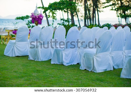 Rows of white covered chairs for asian buddhist wedding ceremony