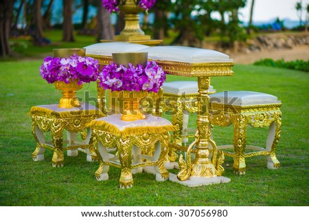 Asian buddhist wedding ceremony chairs and tables of gold for groom and bride with flowers