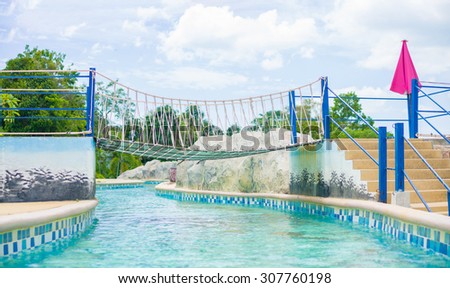 Songkhla, 01 july 2015: Rope bridge above looped river pool in open air aqua aprk of Songkhla zoo in Songkhla town, Songkhla province, Thailand.