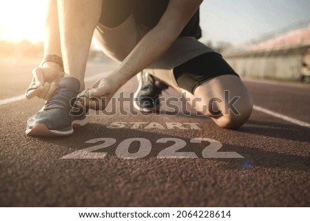 2022 symbolises the start into the new year.Start of people running on street,with sunset light.Goal of Success	