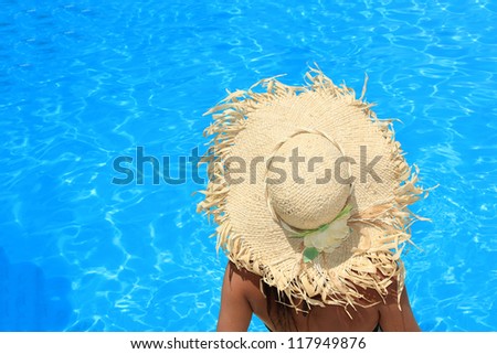 Young woman sitting on the ledge of the pool.