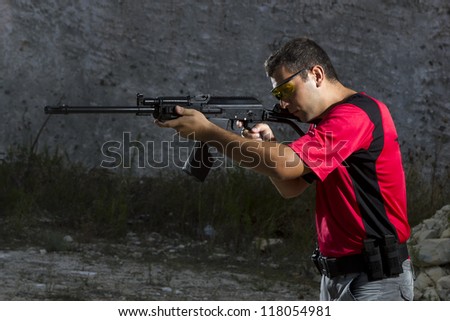 Man shooting on an outdoor shooting range, selective focus
