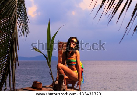 Asian model posing on Long tail fishing boat on the beach in Thailand