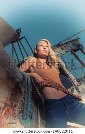 portrait of sexy blonde woman posing at shipwreck