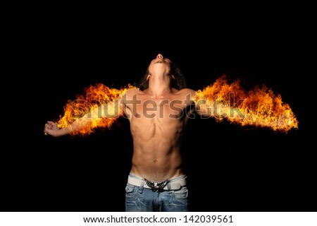 Handsome muscle man with long hair is on fire