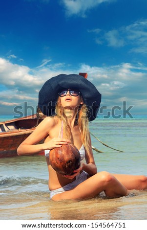 Beautiful woman on the beach with long tail boat in  Thailand.