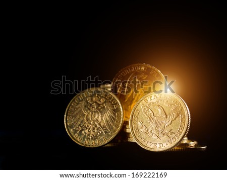 Three gold coins over black background