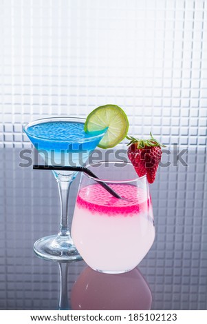 Molecular mixology - Cocktail with blue caracao and strawberry caviar in a martini glass